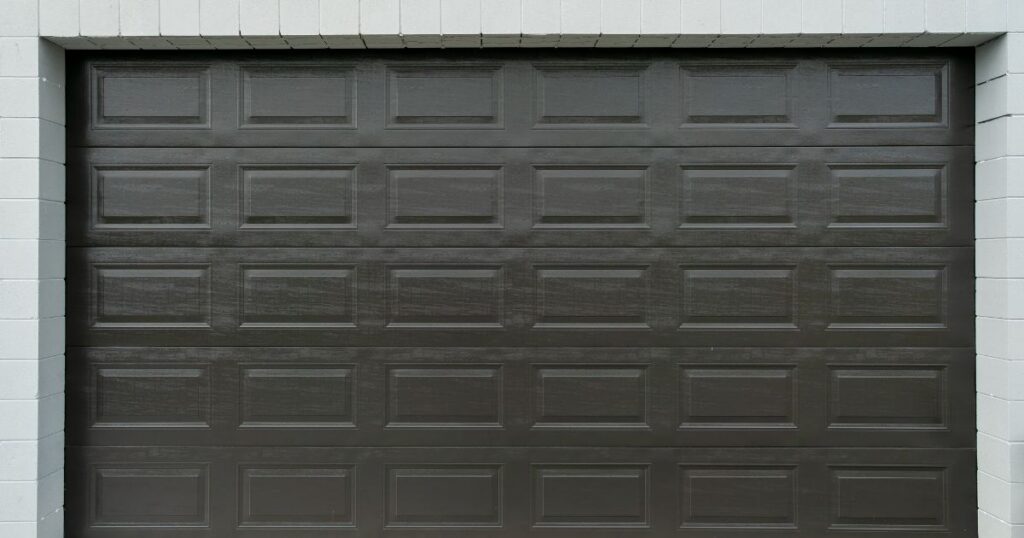 Garage door specialist measuring opening and reviewing panel construction for precise fit