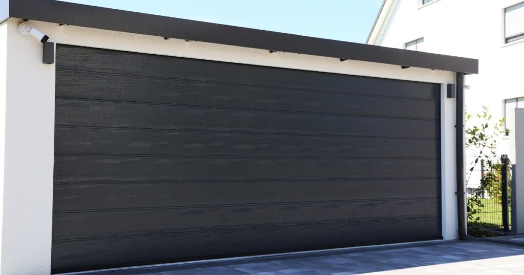Property owner comparing insulated garage door samples for rural home upgrade